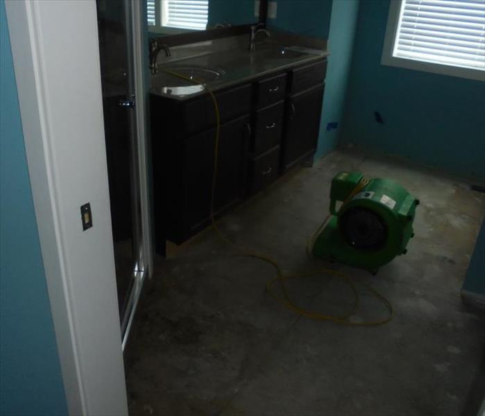 water damaged bedroom.  Flooring removed. SERVPRO drying equipment working to remove moisture